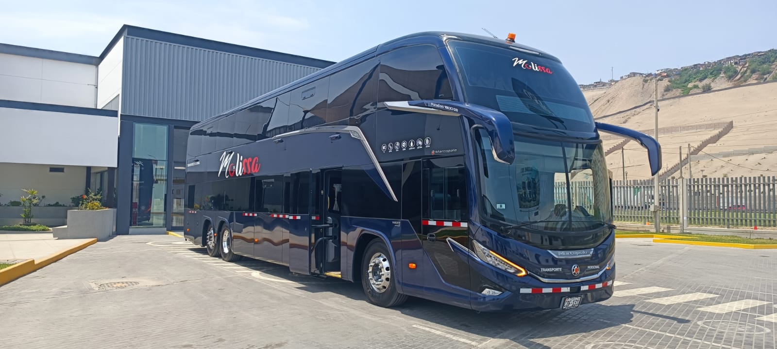 Conductor profesional revisando tablet con sistema de gestión de flota frente a un bus moderno